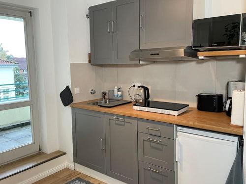 奥尔登堡Modernes Apartment in Oldenburg的厨房配有灰色橱柜和台面