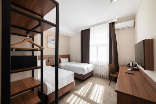 比什凯克Freedom hotel Bishkek的酒店客房设有两张双层床和电视。