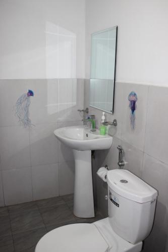 尼甘布Olideb Gedara的白色的浴室设有卫生间和水槽。