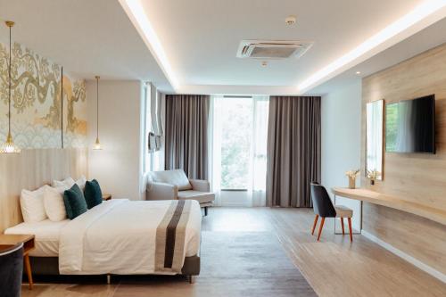大城RUS Hotel&Convention Ayutthaya的配有一张床和一张书桌的酒店客房