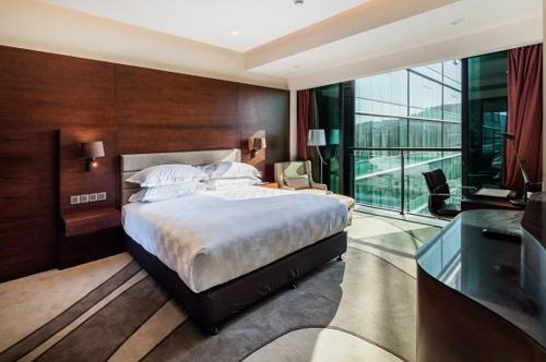 莫尔兹比港斯坦利套房酒店 的一间卧室设有一张大床和一个大窗户