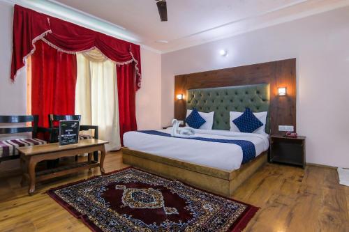 马拉里FabHotel The Moon的一间卧室配有一张带红色窗帘的大床