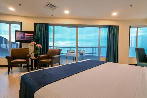 乔治市海滩火烈鸟的酒店客房设有一张大床和一个阳台。