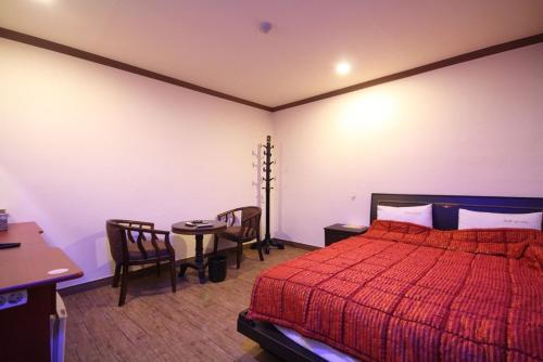 釜山Shine Motel的卧室配有一张床和一张桌子及椅子