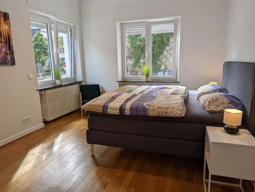 卢森堡Refurbished 1BR Apartment in Limpertsberg的一间卧室设有一张床和两个窗户。