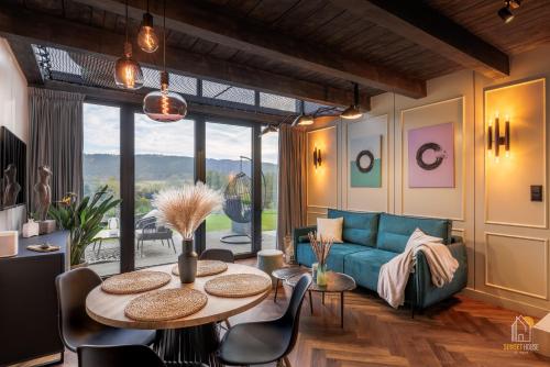 下乌斯奇基Sunset House & Spa的客厅配有蓝色的沙发和桌子