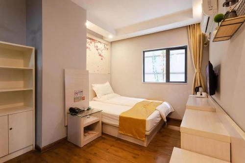 深圳七橙酒店(深圳北站民治店)的一间小卧室,配有床和窗户