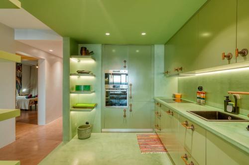 丰沙尔Oceanfront 2-bedroom Apartment in Praia Formosa的绿色厨房配有水槽和冰箱