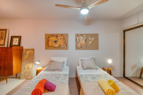 丰沙尔Oceanfront 2-bedroom Apartment in Praia Formosa的墙上画作的房间里设有两张床