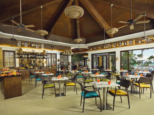 长滩岛长滩岛莫文皮克度假村的一间带桌椅的餐厅和一间酒吧