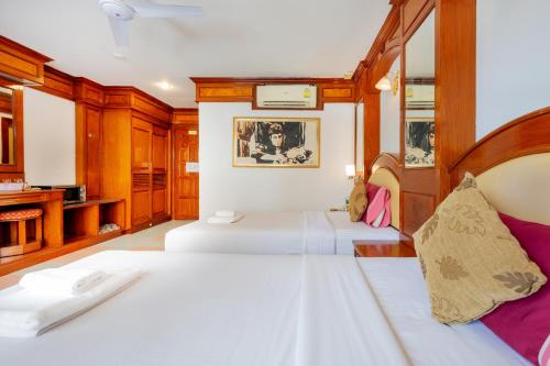 芭东海滩拉迈酒店的一间带两张床的卧室和一间浴室