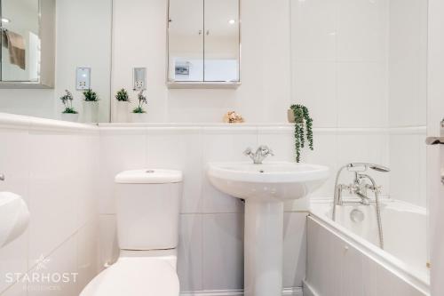 纽伯里Central 3 bed apartment at Regents Court, Newbury的白色的浴室设有卫生间和水槽。