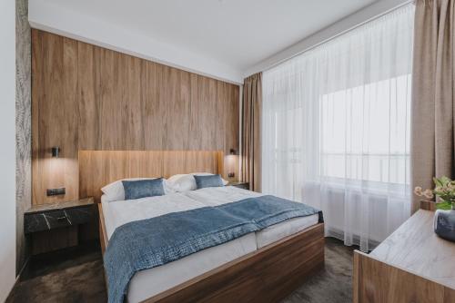 卡鲁扎魅力酒店的一间卧室设有一张床和一个大窗户