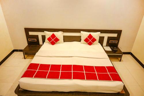 奥兰加巴德FabHotel Sparkling Pearl的一张带红色和白色枕头的床