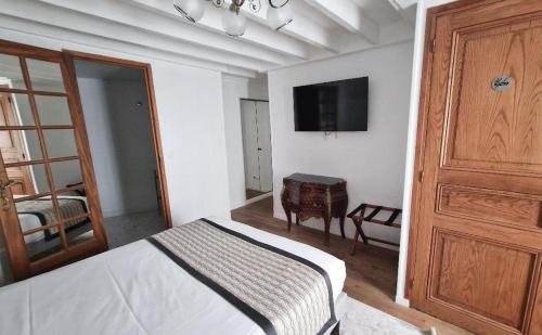 鲁昂鲁昂中心丹迪酒店的卧室配有一张床,墙上配有电视。