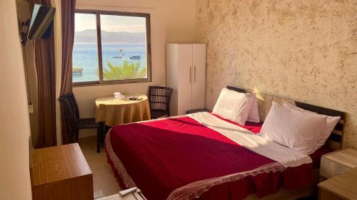 亚喀巴Al-Amer Hostel 2的一间卧室设有一张床,享有海景