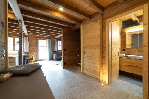 维尔德豪斯Chalet Selun的一间设有木墙的客房和一间带桌子的厨房