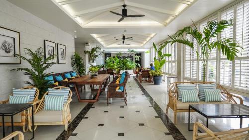 卡伦海滩Sugar Marina Hotel - ART - Karon Beach - SHA Plus的用餐室配有桌椅和植物