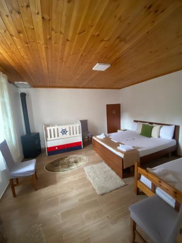 地拉那VILA DISHA的一间卧室设有两张床和木制天花板