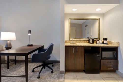 圣路易斯-奥比斯保汉普顿圣路易斯奥比斯波套房酒店的客房设有带椅子和镜子的书桌