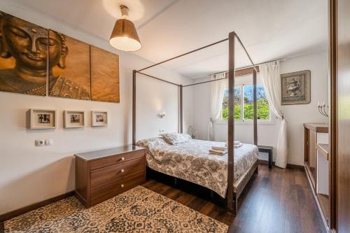 马略卡岛帕尔马Evamas的一间卧室设有天蓬床和窗户。