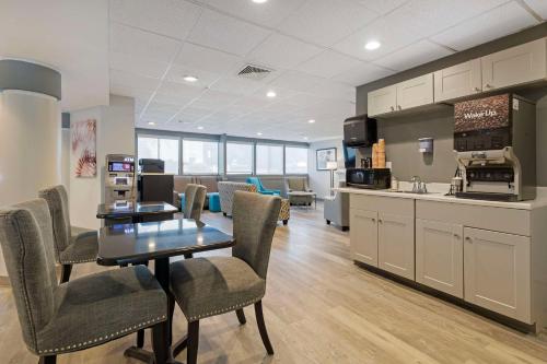 巴尔的摩Clarion Hotel & Suites BWI Airport North的厨房以及带桌椅的用餐室。