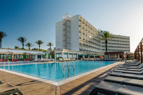 萨尔加Alua Illa de Menorca的大楼前设有游泳池的酒店