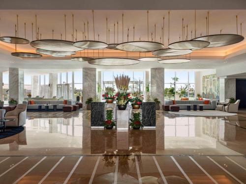 沙姆沙伊赫Rixos Golf Villas And Suites Sharm El Sheikh的大厅,在大楼里长沙发和鲜花