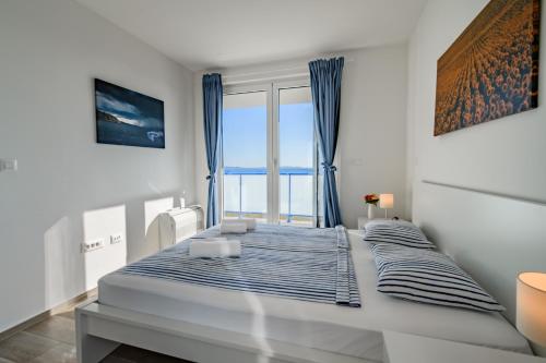 普利拉卡Villa Miri III的白色卧室配有一张带蓝色窗帘的大床