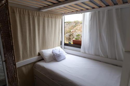 Almáciga卡萨那格公寓的窗户客房内的一张床位