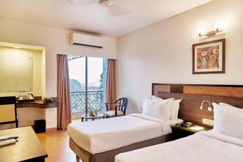 波尔沃林Hotel Orion Centrally near North Goa & Panjim的酒店客房设有两张床和一个阳台。