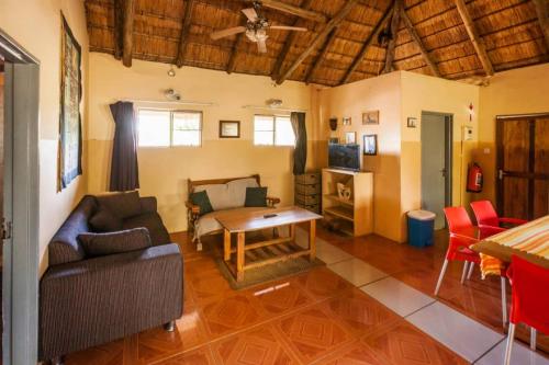 卡萨内African Sunsets (Bophirimo Self-Catering Guest House)的客厅配有沙发和桌子