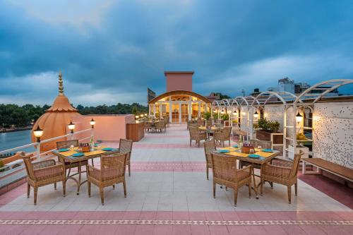哈里瓦Ganga Lahari by Leisure Hotels的阳台餐厅,配有桌椅