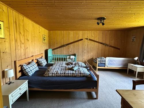 FrauenkirchIdyllisch gelegene grosszügige Ferienwohnung Chumma的木制客房内的一间卧室配有两张床