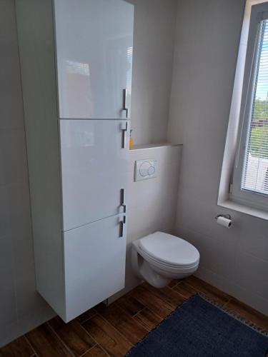 Apartmán Radenice的白色的浴室设有卫生间和窗户。