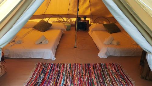 利亚沃尔西Camping Llavorsi的帐篷内带3张床的房间,铺着地毯