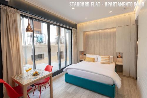 阿利坎特UNIQ flats的酒店客房配有床、桌子和桌子。