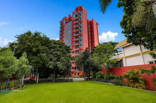 班加罗尔Lemon Tree Suites, Whitefield, Bengaluru的一座红色的建筑,前面有一个公园