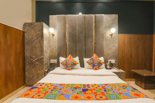 FaizābādFabHotel Royal Palm Inn的一间卧室配有一张大床和色彩缤纷的毯子