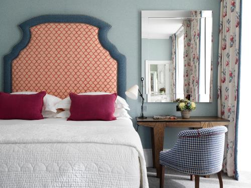 伦敦菲尔姆戴尔16号酒店的一间卧室配有一张床、一把椅子和镜子