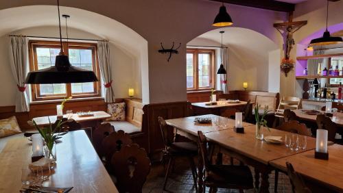 菲施巴豪Hotel Landgasthof Alter Wirt的餐厅设有木桌、椅子和窗户。