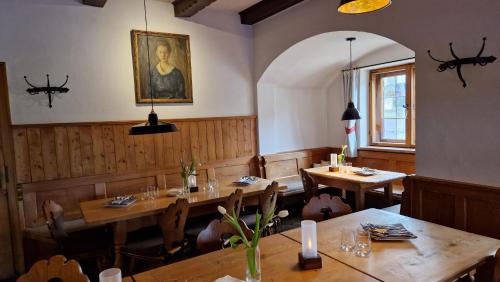菲施巴豪Hotel Landgasthof Alter Wirt的餐厅设有木桌,墙上挂有绘画作品