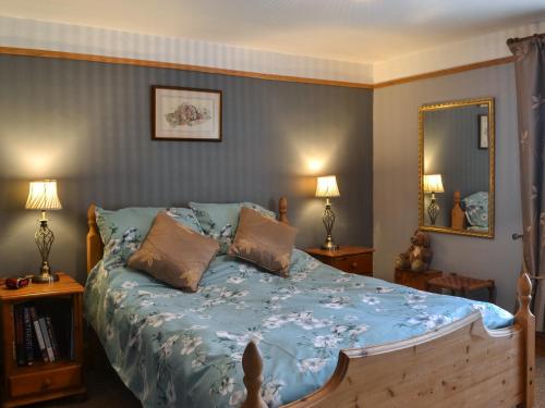 科廷厄姆Second Cottage的一间卧室配有一张带蓝色棉被的床
