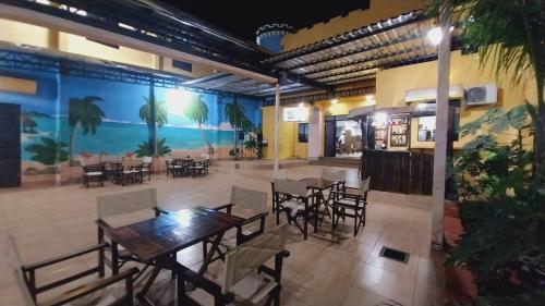 San Juan del ParanáHotel Villa的一间带桌椅和大型壁画的餐厅