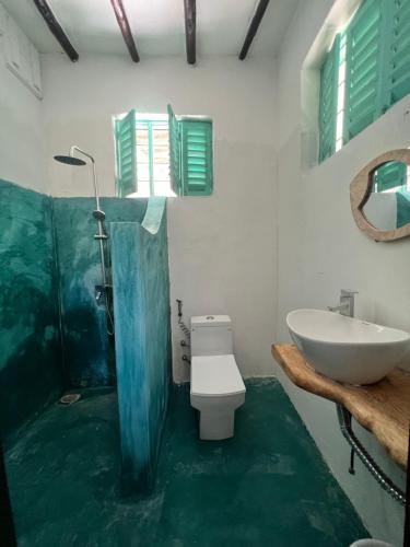 帕杰Duara Beach House的浴室配有白色卫生间和盥洗盆。
