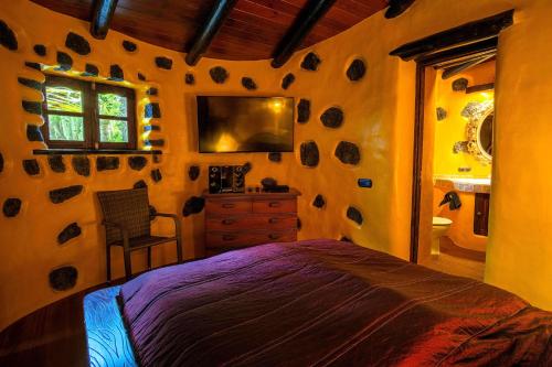 阿索马达Casa La Concha的一间卧室配有一张床、一个梳妆台和一扇窗户。