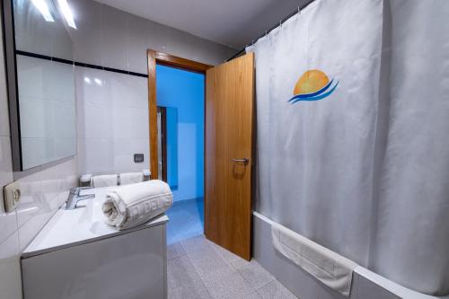 坎帕斯蒂利亚太阳岛公寓酒店的一间带水槽和淋浴帘的浴室