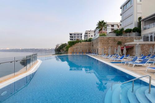 安塔利亚安塔利亚华美达广场酒店的一个带躺椅和水的游泳池