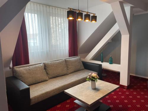 莱比锡柏林酒店的客厅配有沙发和桌子