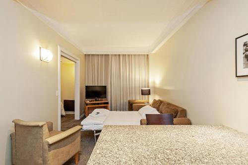 库里提巴Slaviero Curitiba Shopping的一间酒店客房,配有一张床和一台电视